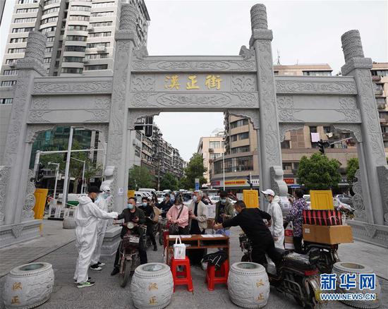  4月16日，進出武漢漢正街步行街的人員在掃描健康碼。新華社記者 王毓國 攝